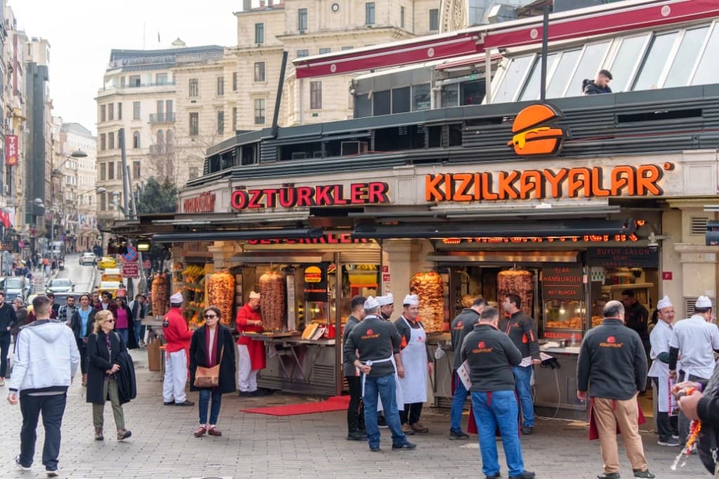 Rue d'Istanbul : enseignes de döner, broches qui tournent, passants sur les pavés.